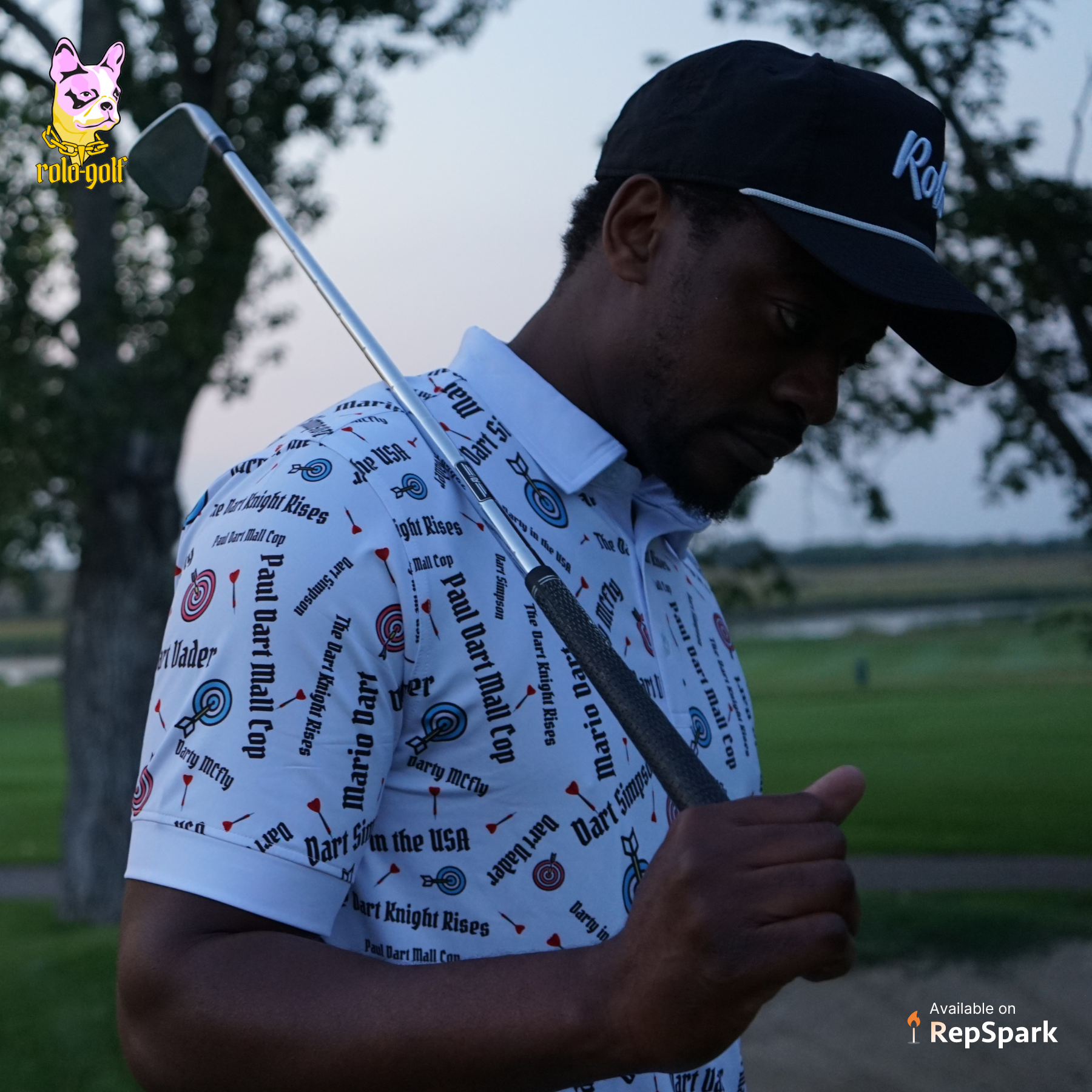 Man wearing colorful golf polo while walking on a golf green with his golf iron slung over his back.