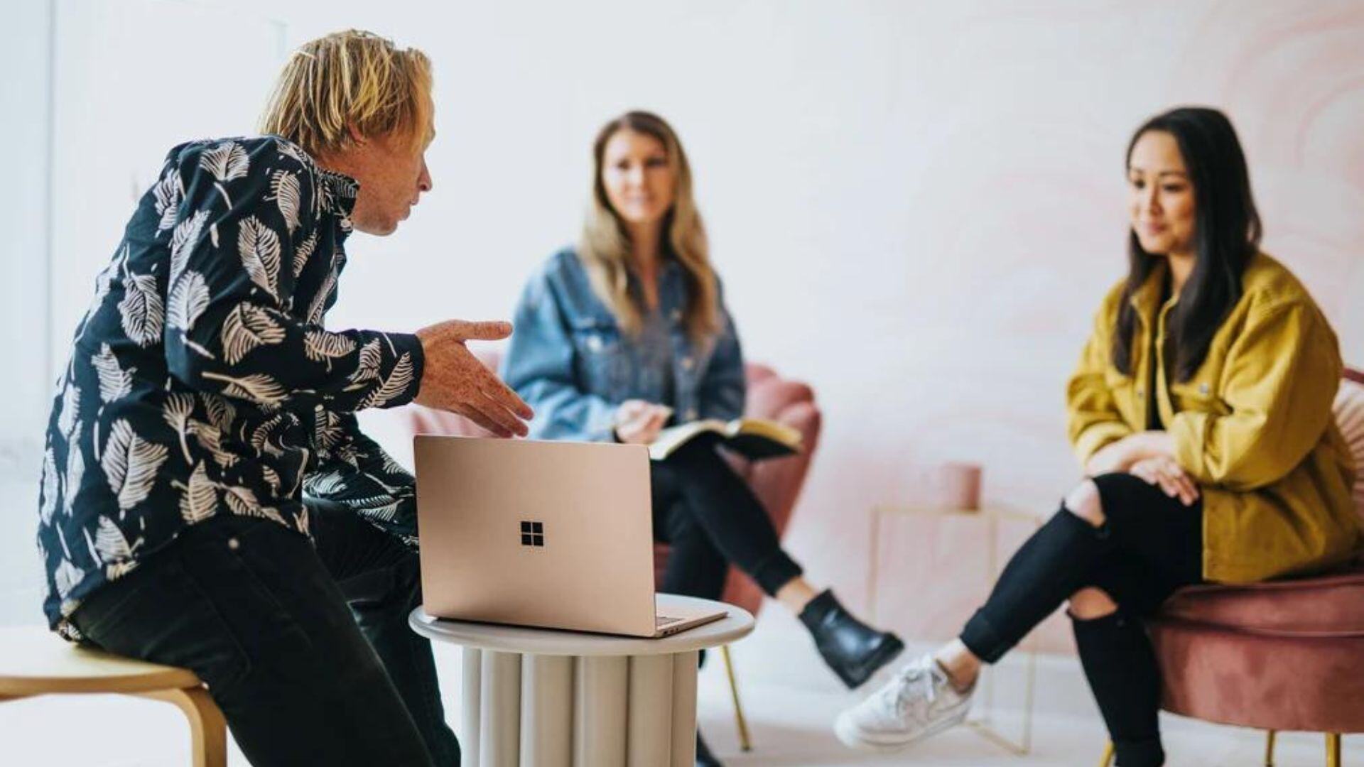 a group of people around a laptop discussing something