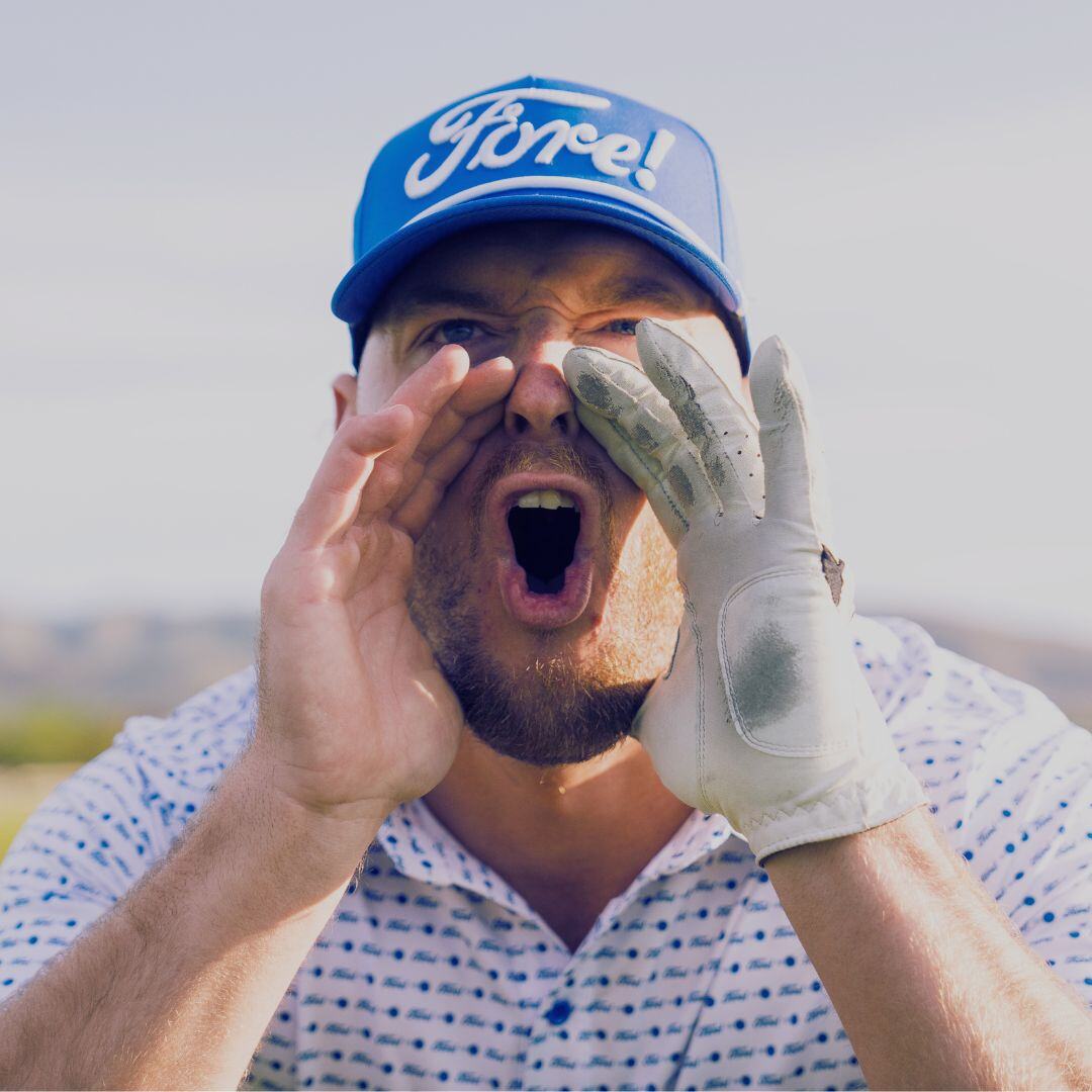 Man with a blue baseball hat cupping his hands around his mouth preparing to yell.