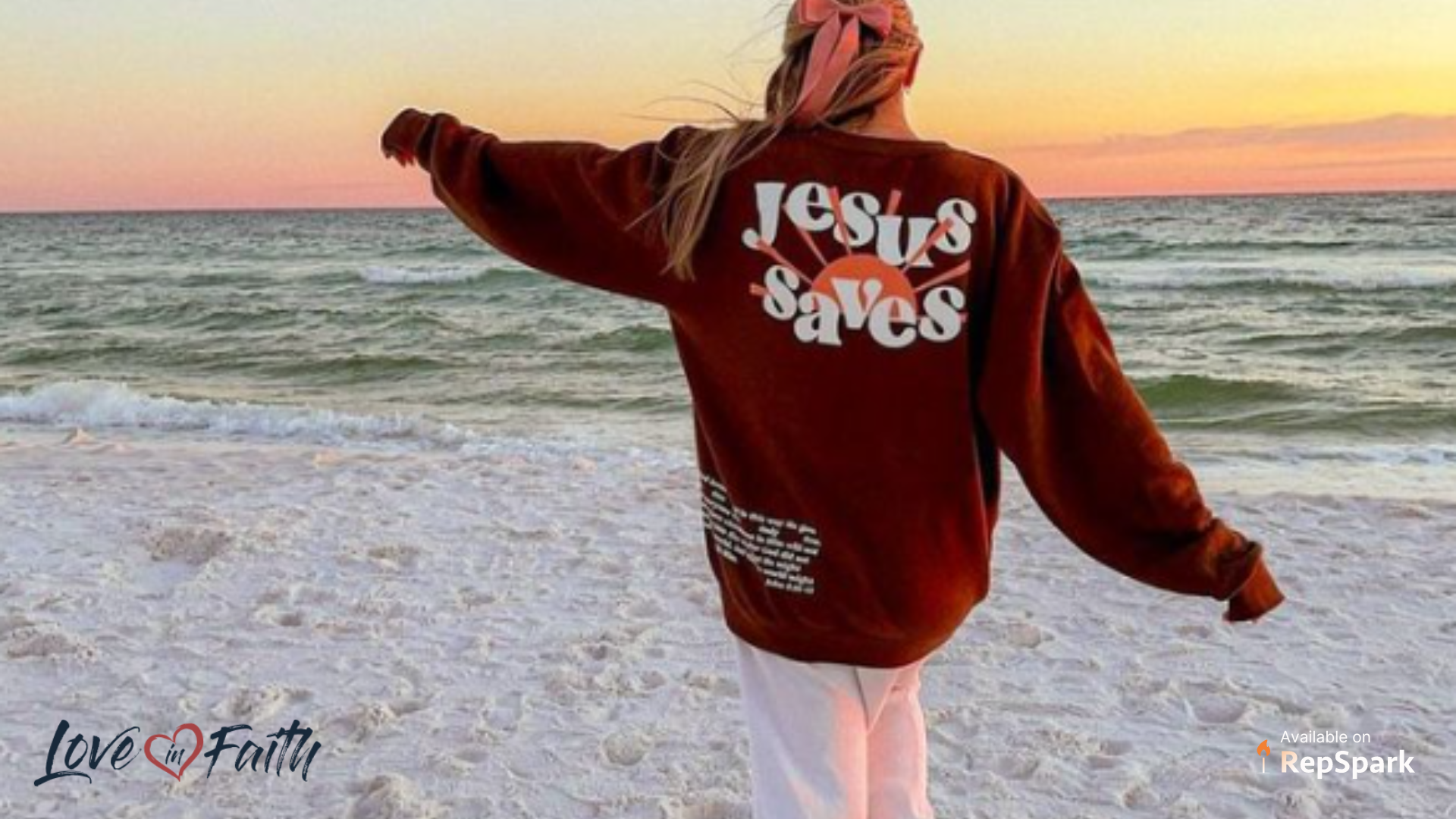 Female walking on the beach at sunset wearing an oversized sweatshirt that says 