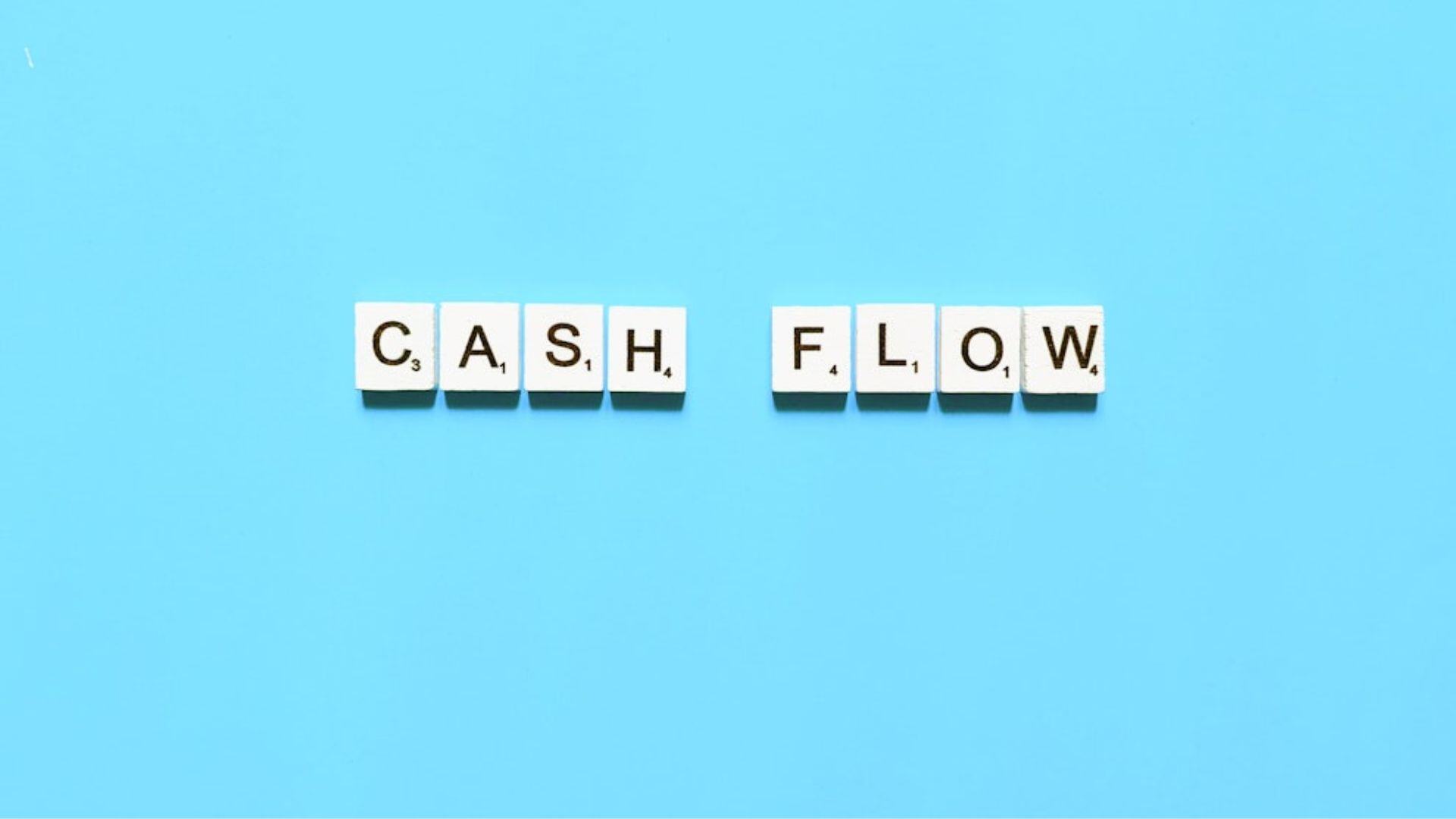 cash flow scrabble pieces to depict the 7 strategies businesses can use to improve their cash flow