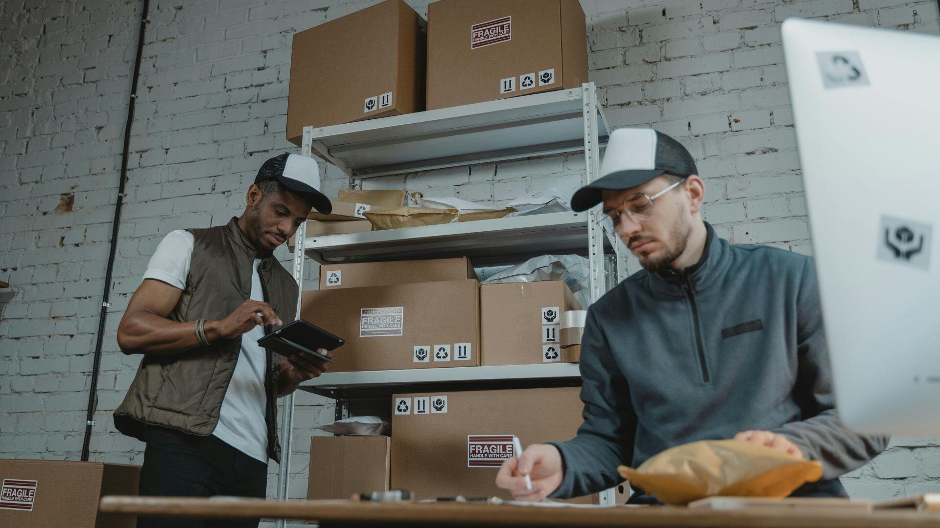 two men in an office tracking their inventory on their computer 