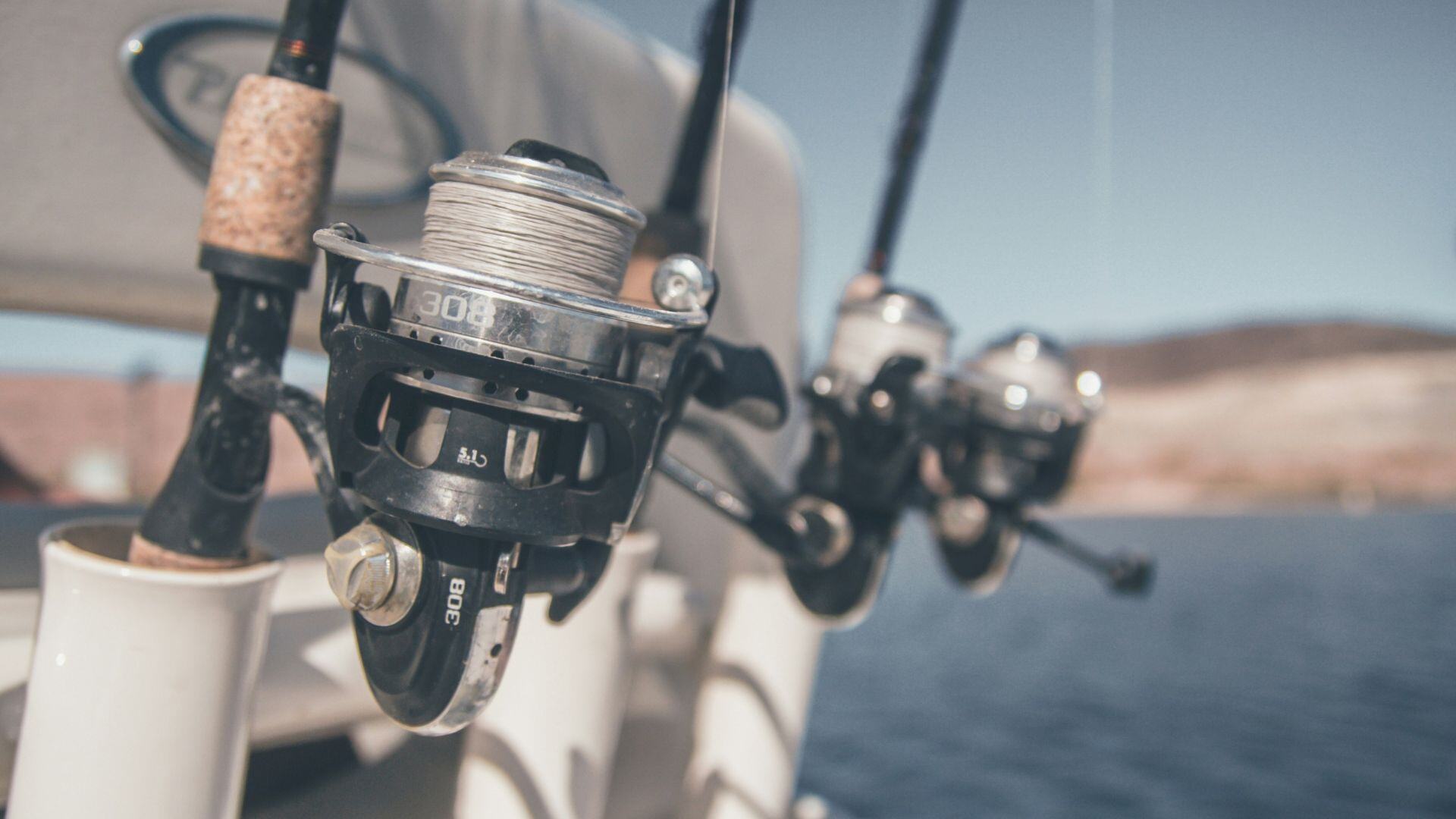 a close-up shot of three fishing rods in fishing rod holders 